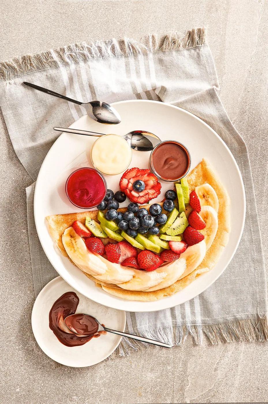 Assiette de fruits frais avec crêpe et crème fouettée